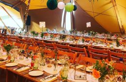 Tipi wedding with rustic furniture and green glassware
