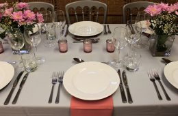 Grey and pink wedding table settings with pink tea light holders and pink flowers